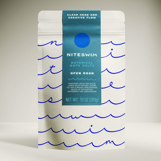 Niteswim botanical bath salts packaging with wavy line design on a neutral background. Open Road bath blend for creativity and manifestation support.
